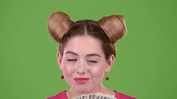 Girl Sniffs Paper Bills and She Is Delighted. Green Screen. Close Up. Slow Motion alt
