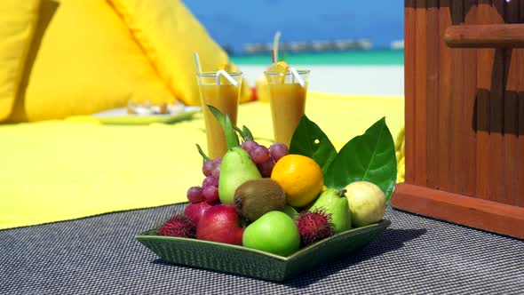 Close up detail of a fruit plate at a picnic on a tropical island beach. alt