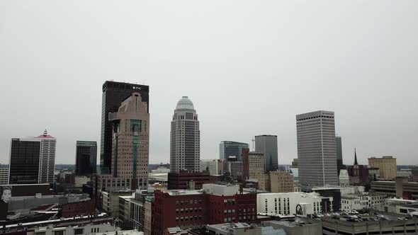 4k aerial view of drone flying toward downtown Louisville, Kentucky skyline on a winter day