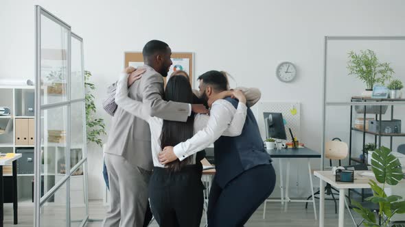 Multiethnic Group of People Collegues Jumping and Hugging Then Clapping Hands in Office alt