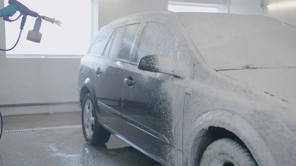 Car washing and detailing. Professional worker is washing a car. Slow mo. Transport disinfection. alt