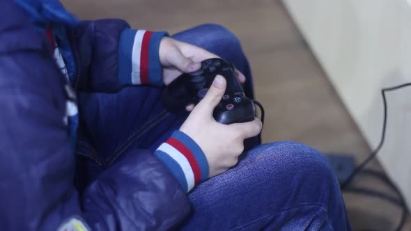 Man In The Helmet Of Virtual Reality Uses The Gamepad alt