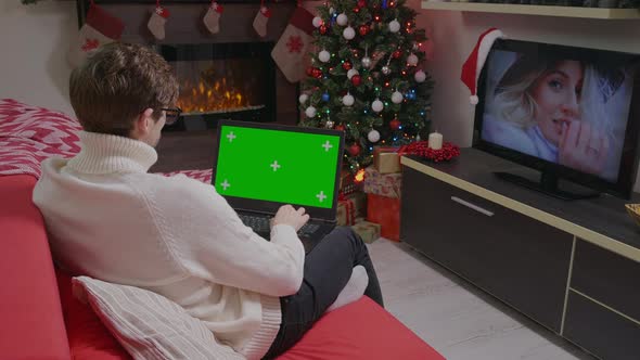 Man using laptop on Christmas holidays. Laptop Green Screen Chroma Key. alt