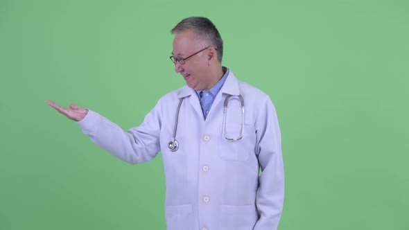 Excited Mature Japanese Man Doctor Comparing Something alt