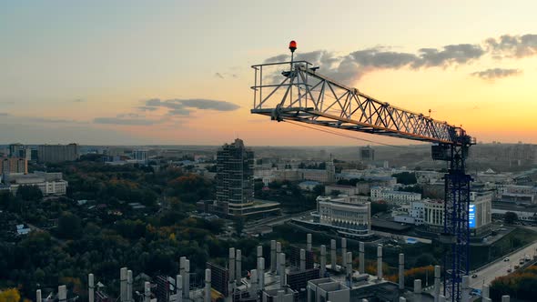 Building Crane Is Moving at the Urban Construction Yard. Construction Site at a Sunset. alt