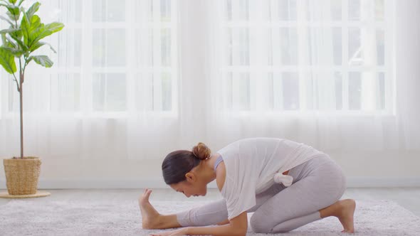Calm of wellness Asian young woman sit on bed breathing and stretching before do yoga alt