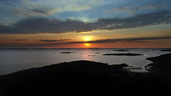 Aerial beautiful sunset at a rocky coastline with a marina and islands in an archipelago.