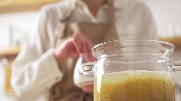 Glass Transparent Pot With Boiling Water, Spaghetti. Female Chef Adds Salt Pasta. Cooking At Home alt