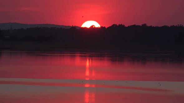 Sunset across a tranquil lake in Thailand.