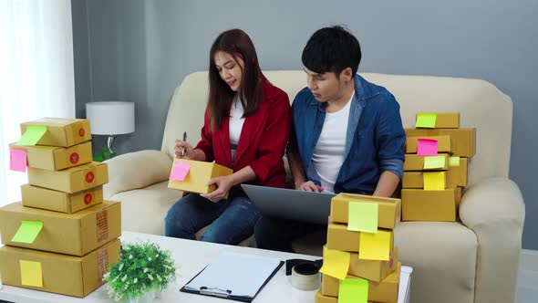 couple entrepreneur working with laptop computer prepare parcel boxes for deliver to customer alt