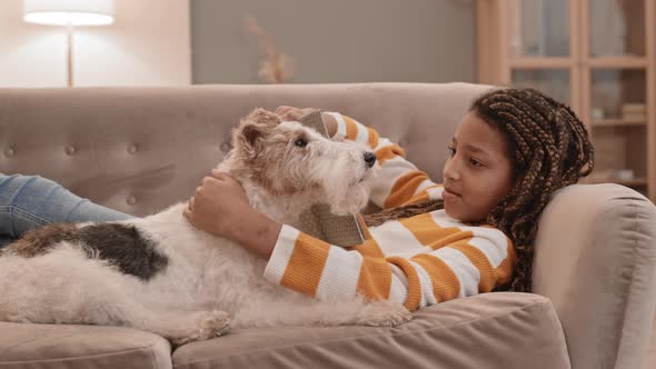Girl and Dog Lounging on Couch alt