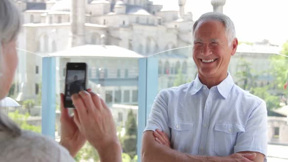 Senior man posing for Female taking picture in front of Blue Mosque, Istanbul, Turkey alt