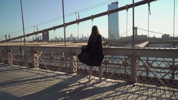 Woman in Black Long Flowing Dress Posing at Brooklyn Bridge in New York