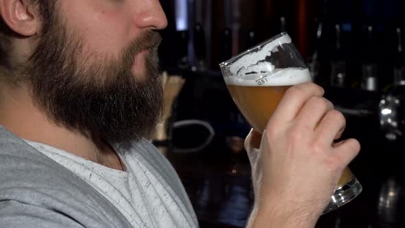 Bearded Man Smiling After Sipping Delicious Beer at the Bar  alt