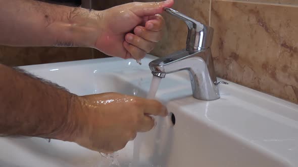 Covid-19 Pandemic: Man Turns Off the Tap After Washing His Hands in Slow Motion alt