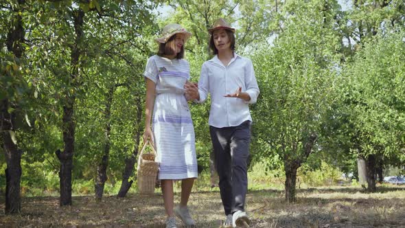 Cute Couple Walking in the Park or Garden Holding Hands, Talking and Smiling alt