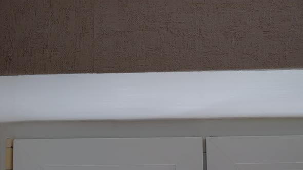 A Woman Paints the Slopes at the Window with White Paint Painting the Window Openings with Paint alt