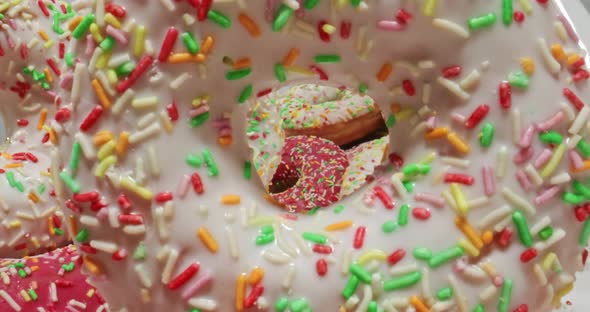 Multi colored donuts with sprinkles. Table with donuts and coffee. alt