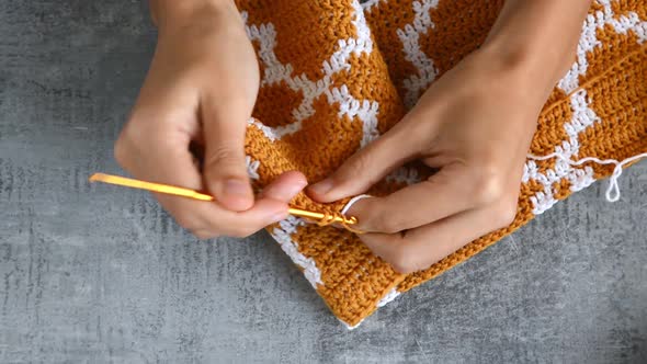 young womans hands crocheting