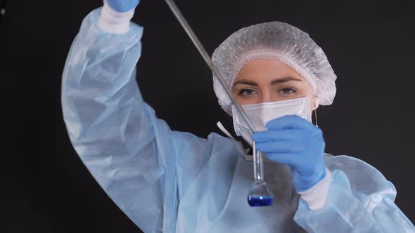 A Drop of Blue Liquid Falls Into a Transparent Vessel From a Glass Tube of a Heat-resistant Water alt