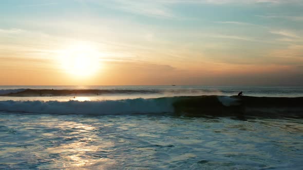 Following large waves at sunset