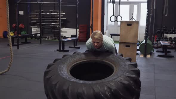 Fitness Woman Doing Big Tire Flips Exercise During Functional Training