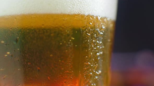 Macro Shot of a Drop Running Over a Glass of Beer. Sweat on a Cold Glass of Beer. A Dripping Drop on alt