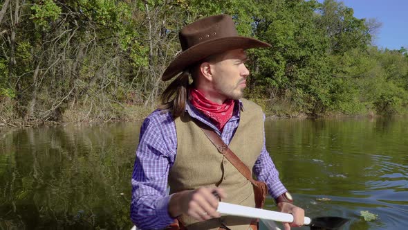 Cowboy in a Canoe Floats on the River alt