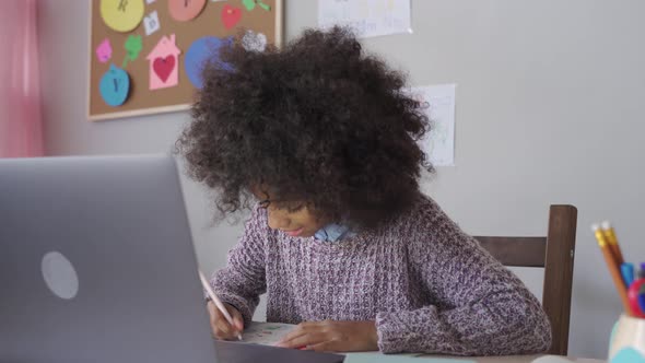 African Kid Girl Video Calling Remote Learning Remote Class on Laptop at Home alt