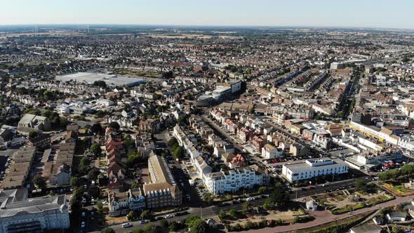 Reverse aerial view of Clacton-on-Sea promenade and parks on a sunny day alt