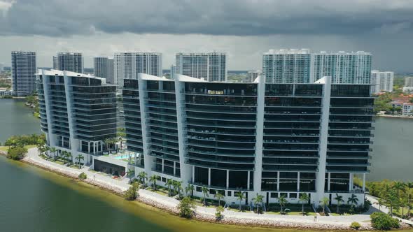 Modern Design Frontline Glass Building on Green Island in Miami Bay, Cloudy Day alt