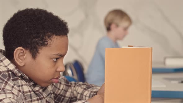 School Boy Using Smartphone during Lesson alt