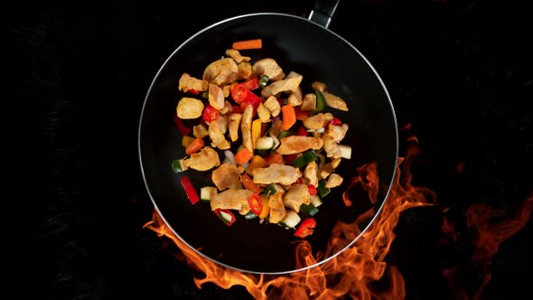 Super Slow Motion Shot of Throwing Chicken Meat Mixture on Frying Pan and Fire Blast at 1000Fps alt