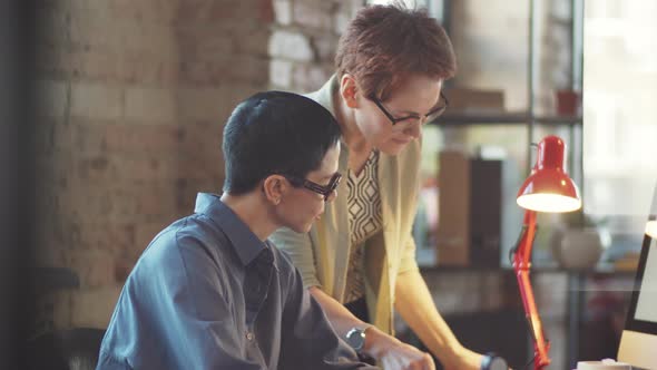 Two Businesswomen Discussing Documents in Office alt