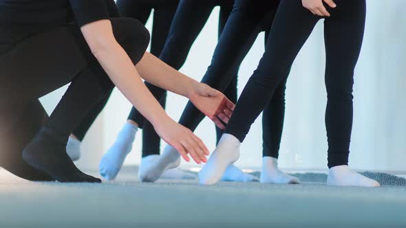 Ballet Teacher in Black Tracksuit Fixes Young Girls Feet alt