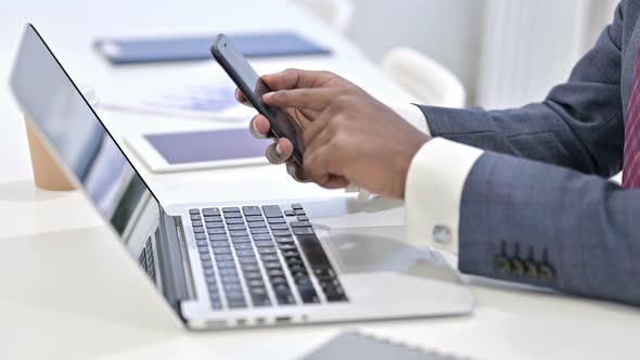 Close Up of Professional African Man Using Smartphone in Office  alt
