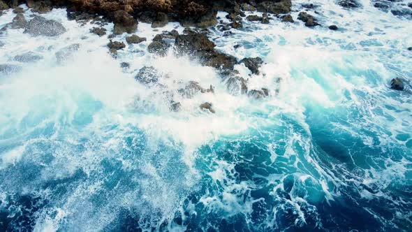 Sea Waves Washes the Rocky Shore Aerial Top View alt