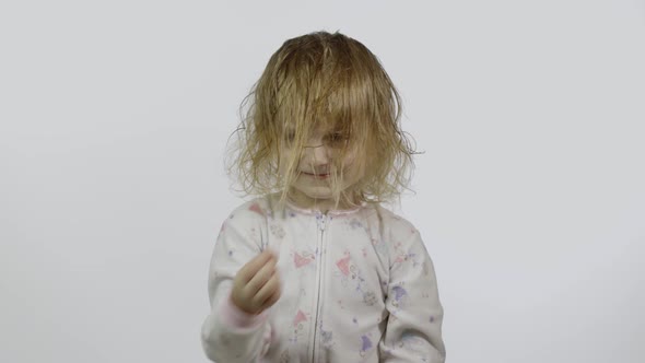 Little Baby Girl in Pajama Is Fooling Around and Make Faces alt