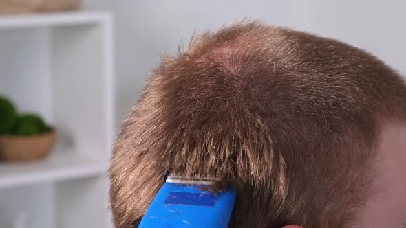 A Man Cuts His Hair with Clipper
