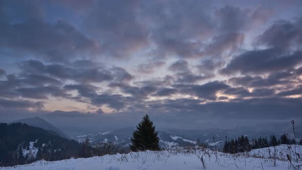 Clouds at sunrise in a winter mountain landscape. alt