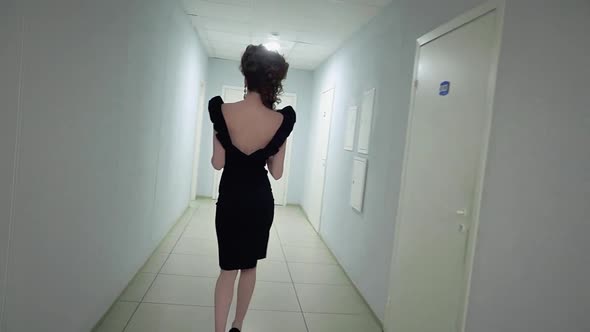 Young Beautiful Girl in the Office in Evening Dress Walking Along the Corridor Slow Motion alt