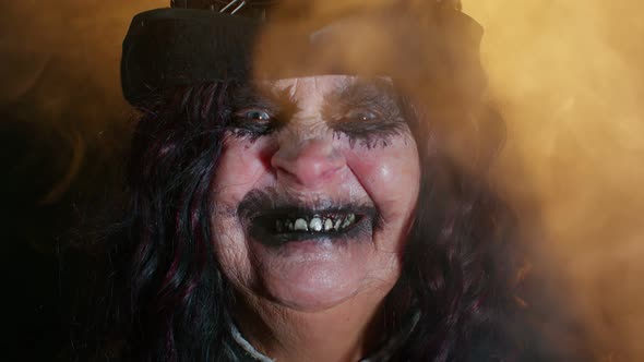 Sinister Senior Mature Woman in Carnival Costume of Halloween Witch Making Faces Trying to Scare alt