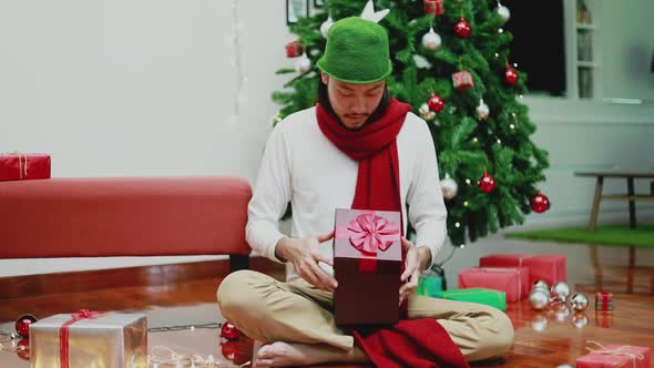 Surprise Asian men open the gift box in the living room at home.