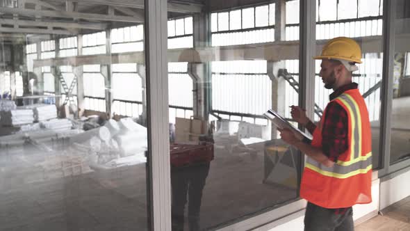 Construction Engineer with Yellow Helmet and Orange Vest at Construction Site alt
