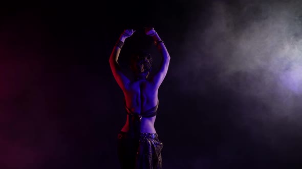 A Woman Who Dances an Oriental Dance on a Black Background in a Studio She Is Dressed in a Revealing alt