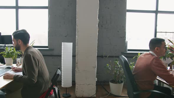 Zoomout of Open Space Office Room and People Employees Working with Computers at Desks alt