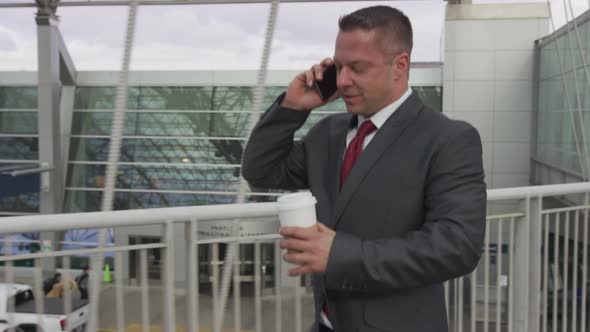 Businessman walking and talking on cell phone at airport