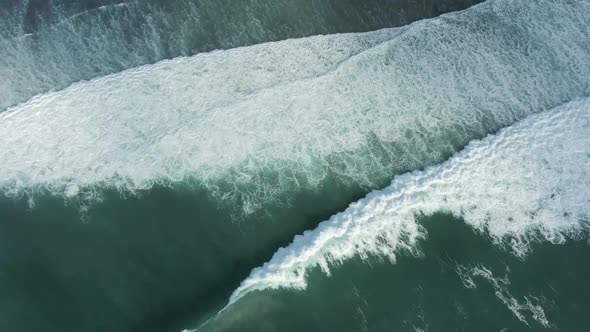 Aerial View Of Ocean Waves Crashing On Shore In Indonesia. alt