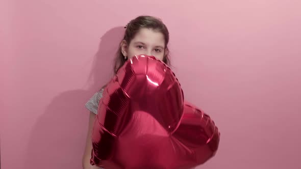 Beautiful Girl on a Pink Background with Present Box and a Red Balloon alt