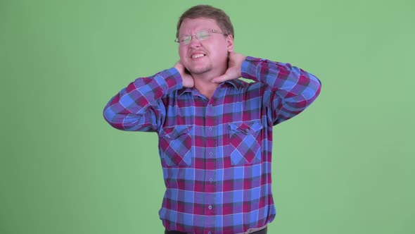 Stressed Overweight Bearded Hipster Man Having Neck Pain alt